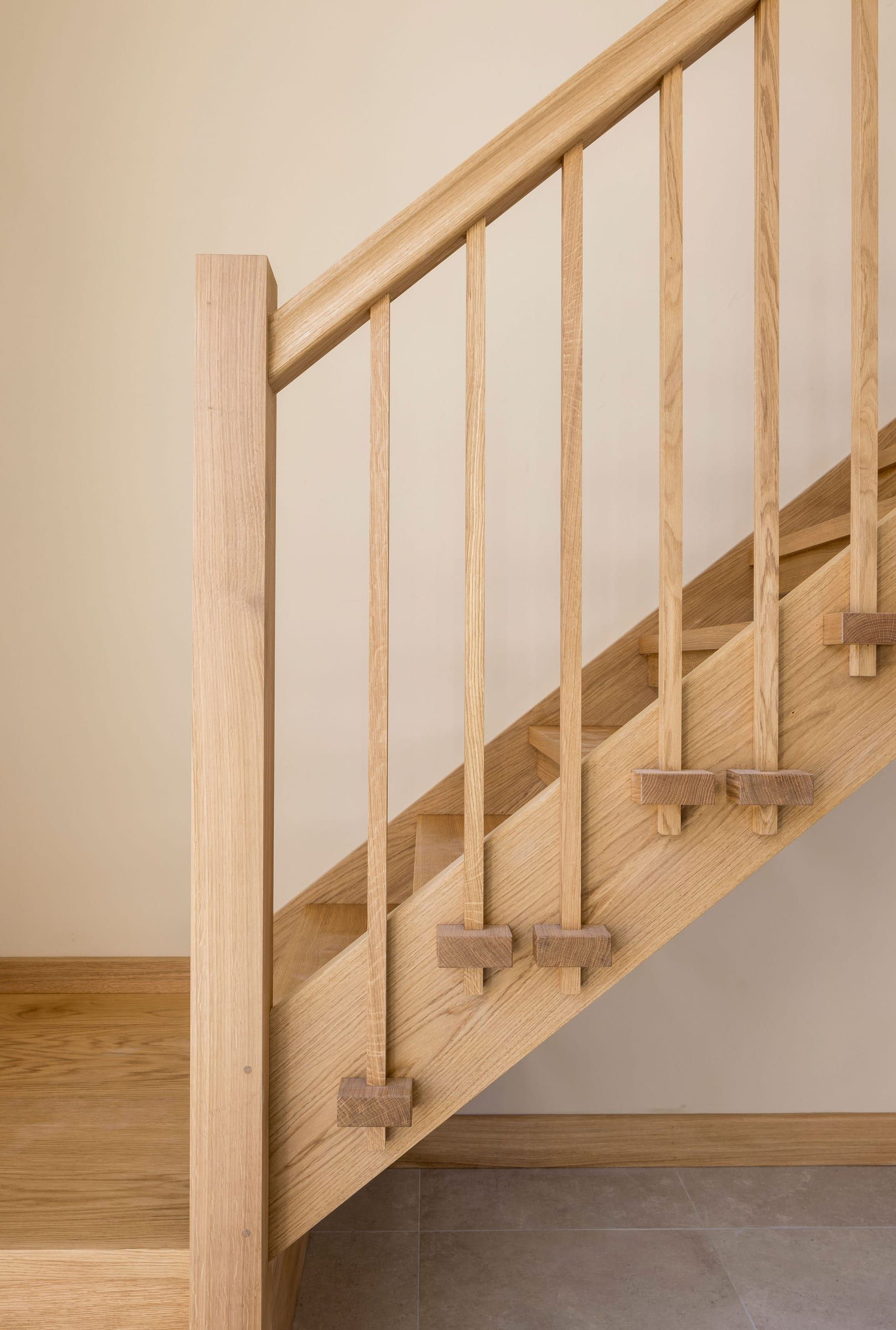Close-up of oak staircase newel post, spindles and open treads