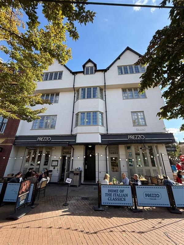 Basing House street facade with new timber windows, ground floor restaurant and outdoor seating