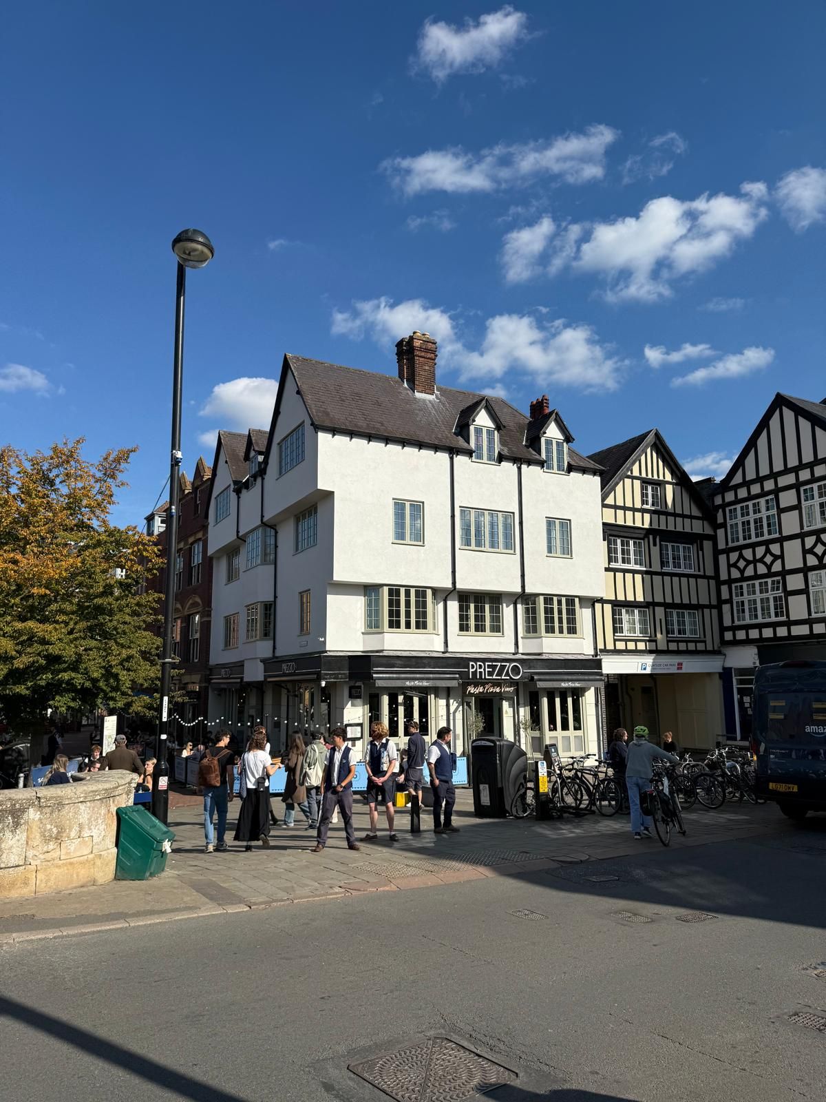 Basing House Tudor-revival corner facade on the street, with pedestrians and cyclists outside