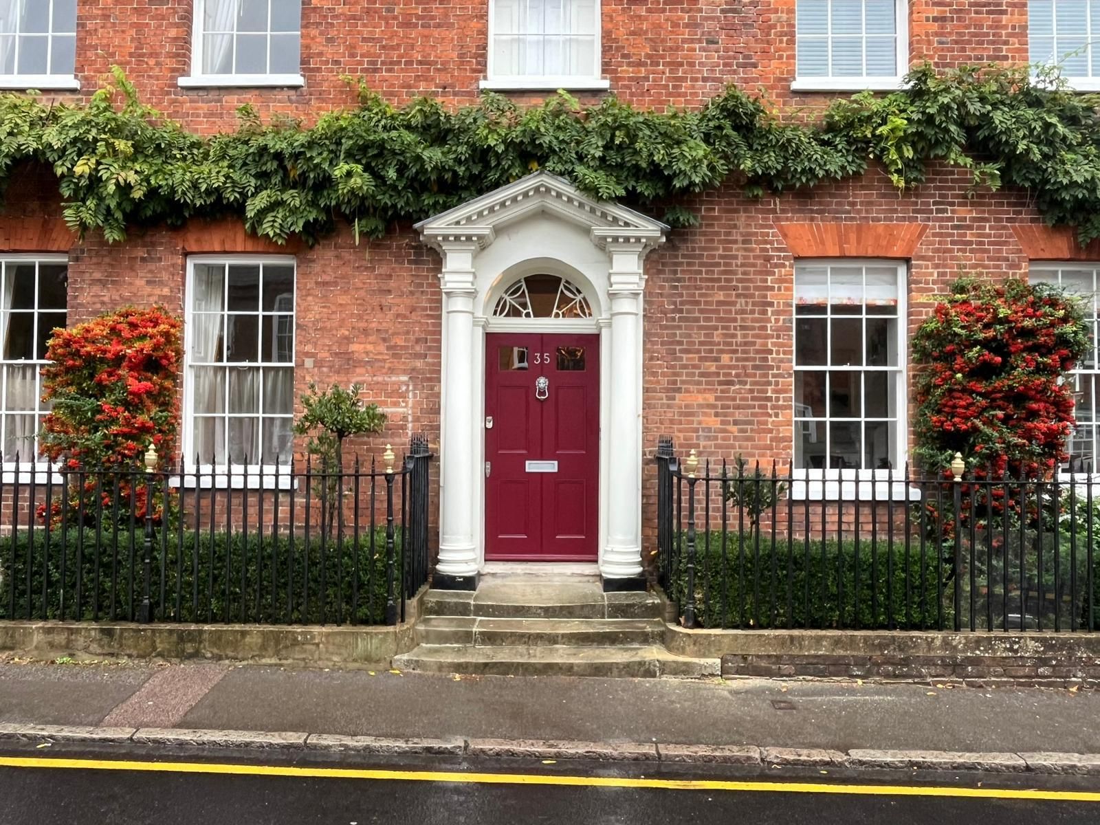 Bespoke burgundy hardwood entrance door with fanlight and white portico