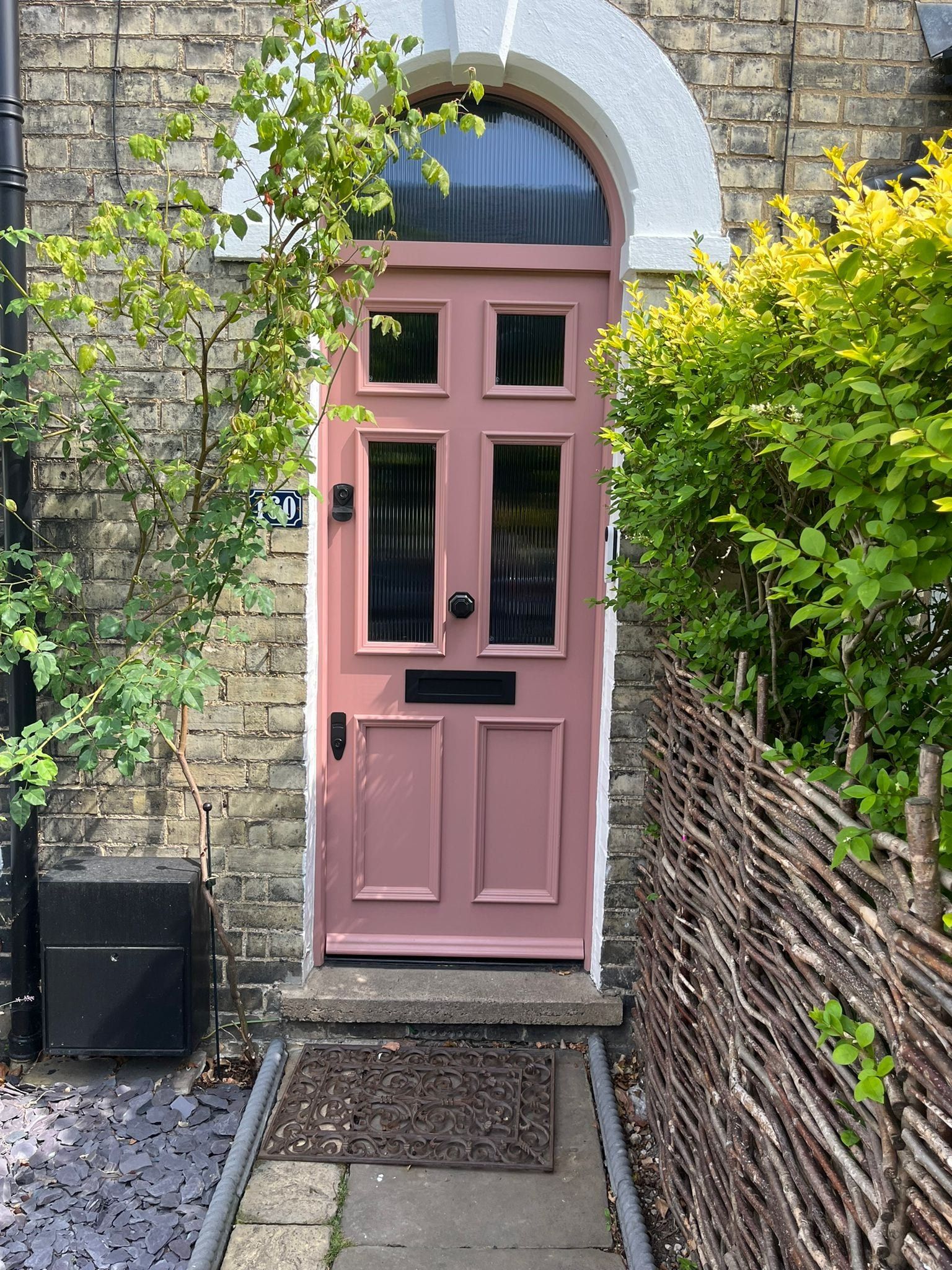 Bespoke pink flush panel entrance door with reeded glass and arched fanlight