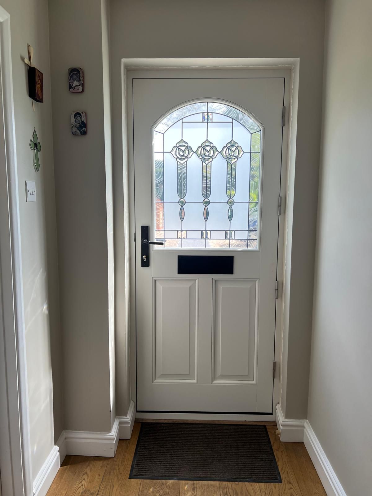 Interior view of white stable-style door with rose stained glass fanlight