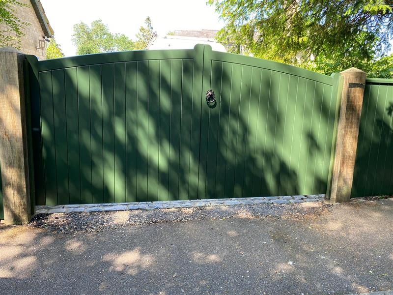 Bespoke green-painted timber driveway gate with wooden gate posts