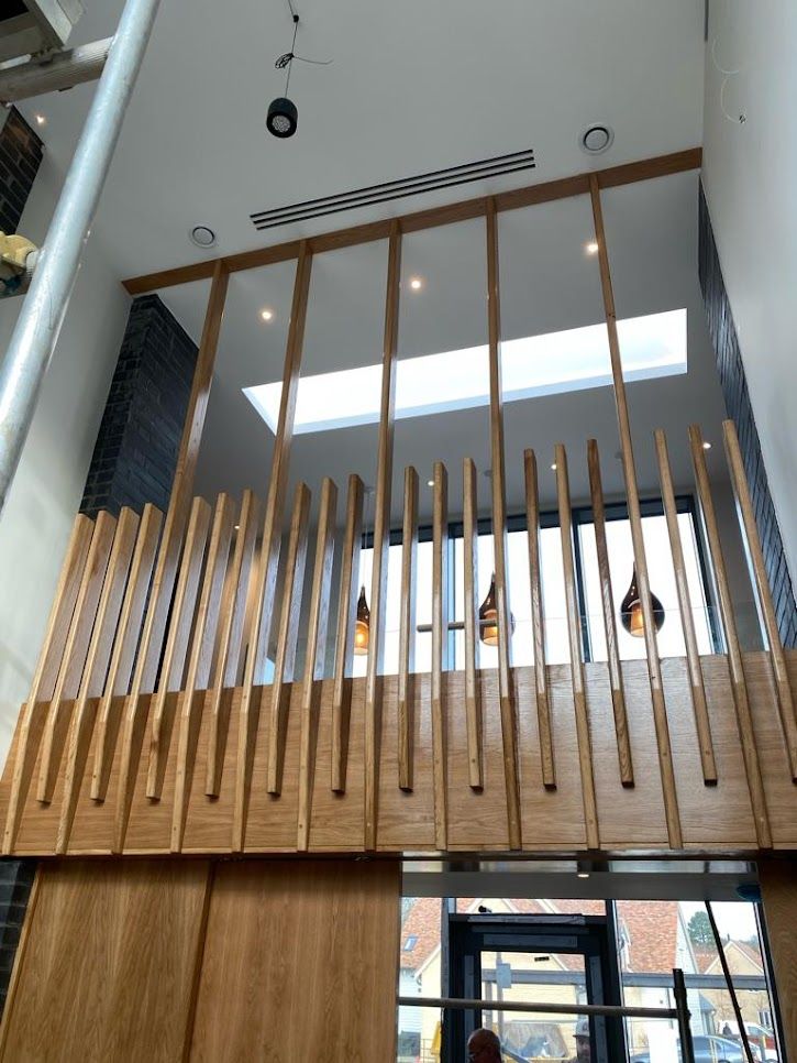 Bespoke oak slatted balustrade and screen on a double-height mezzanine