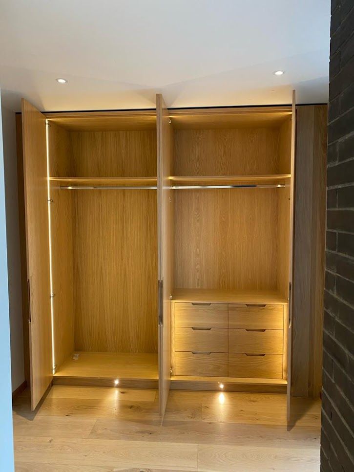 Open fitted oak wardrobe with hanging rail and internal drawers
