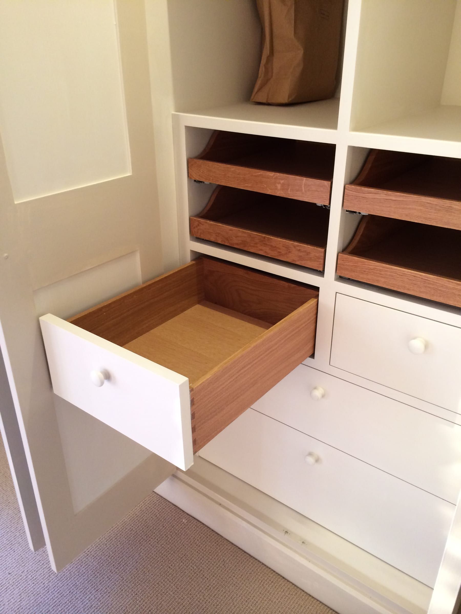 Open wardrobe drawer showing dovetail joinery and internal shelving