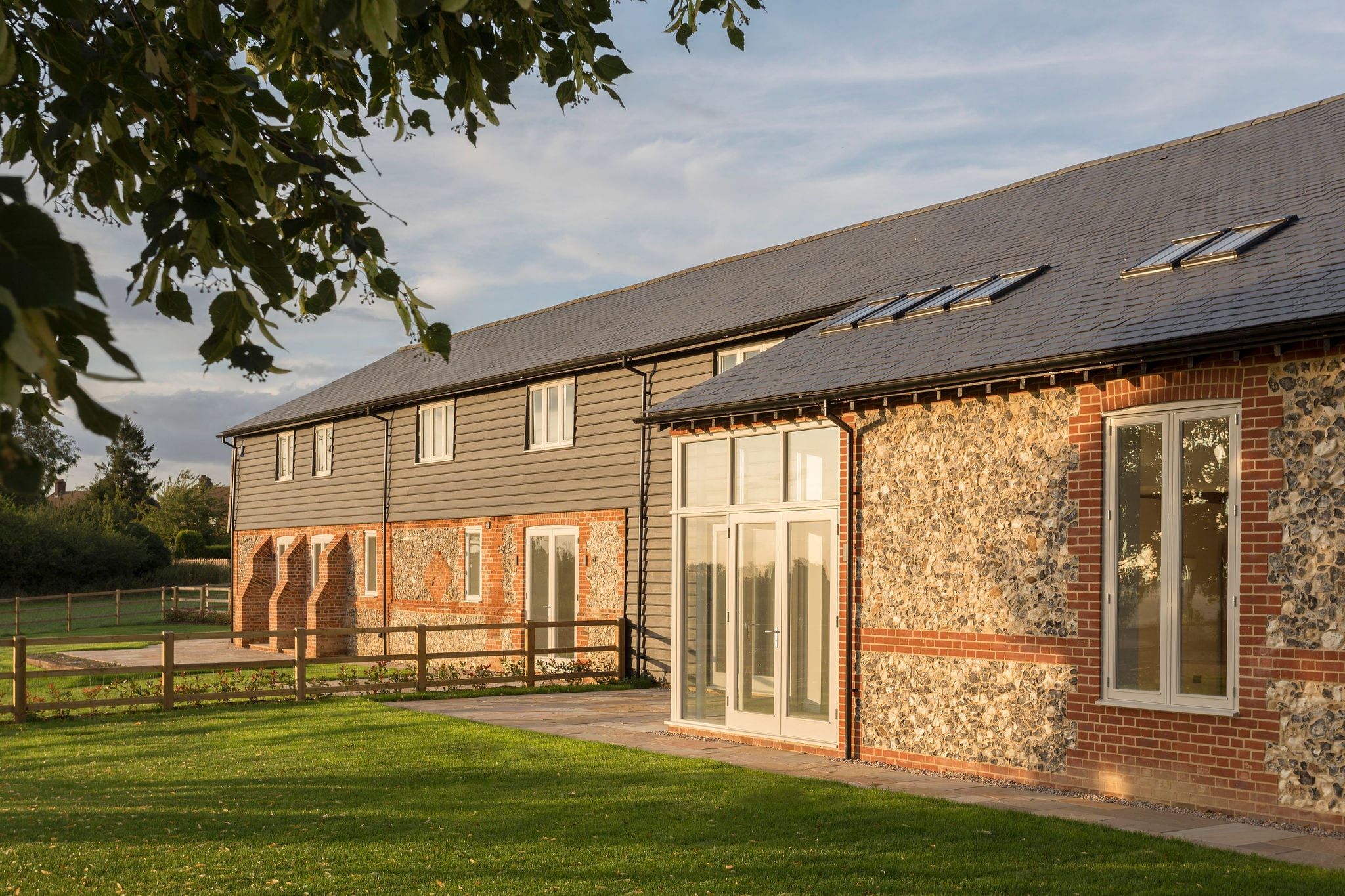 Barn exterior from garden showing glazed entrance doors and timber casement windows