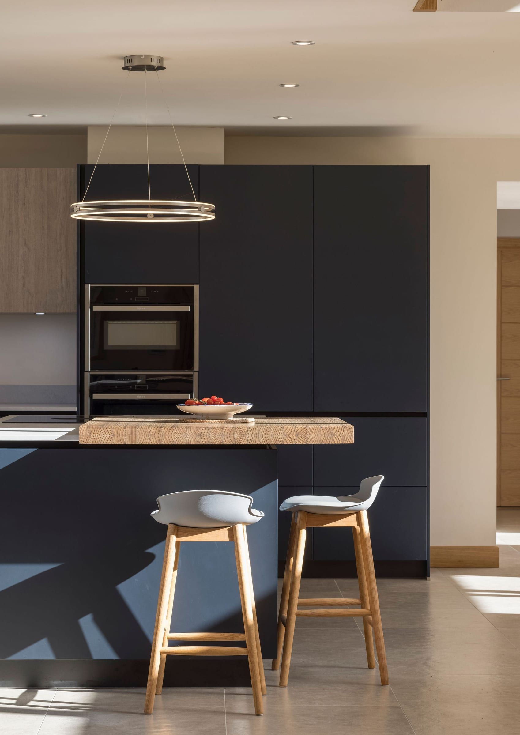 Bespoke navy kitchen island with oak breakfast bar and stools