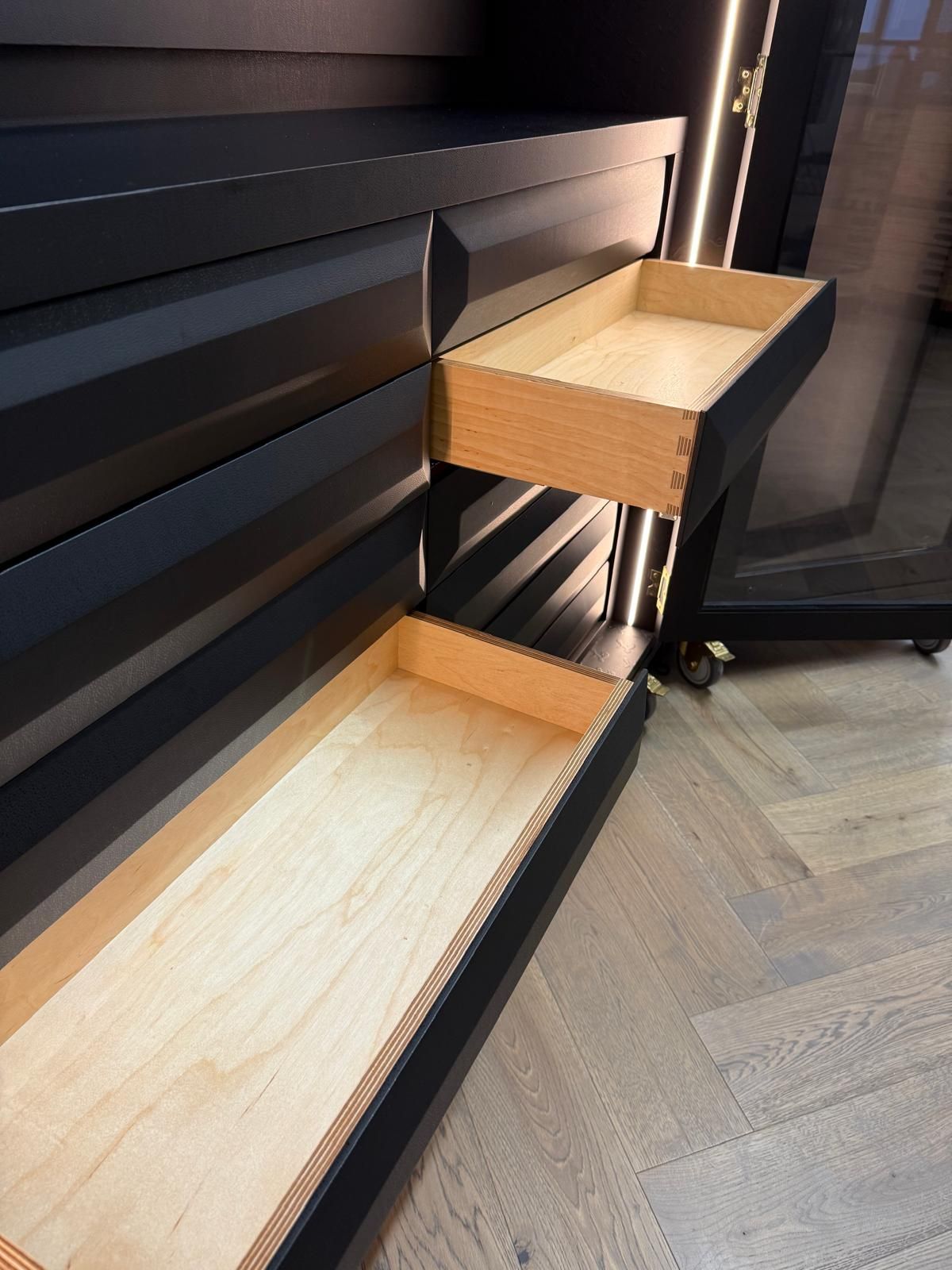 Close-up of open bespoke drawers with dovetail joints and plywood lining