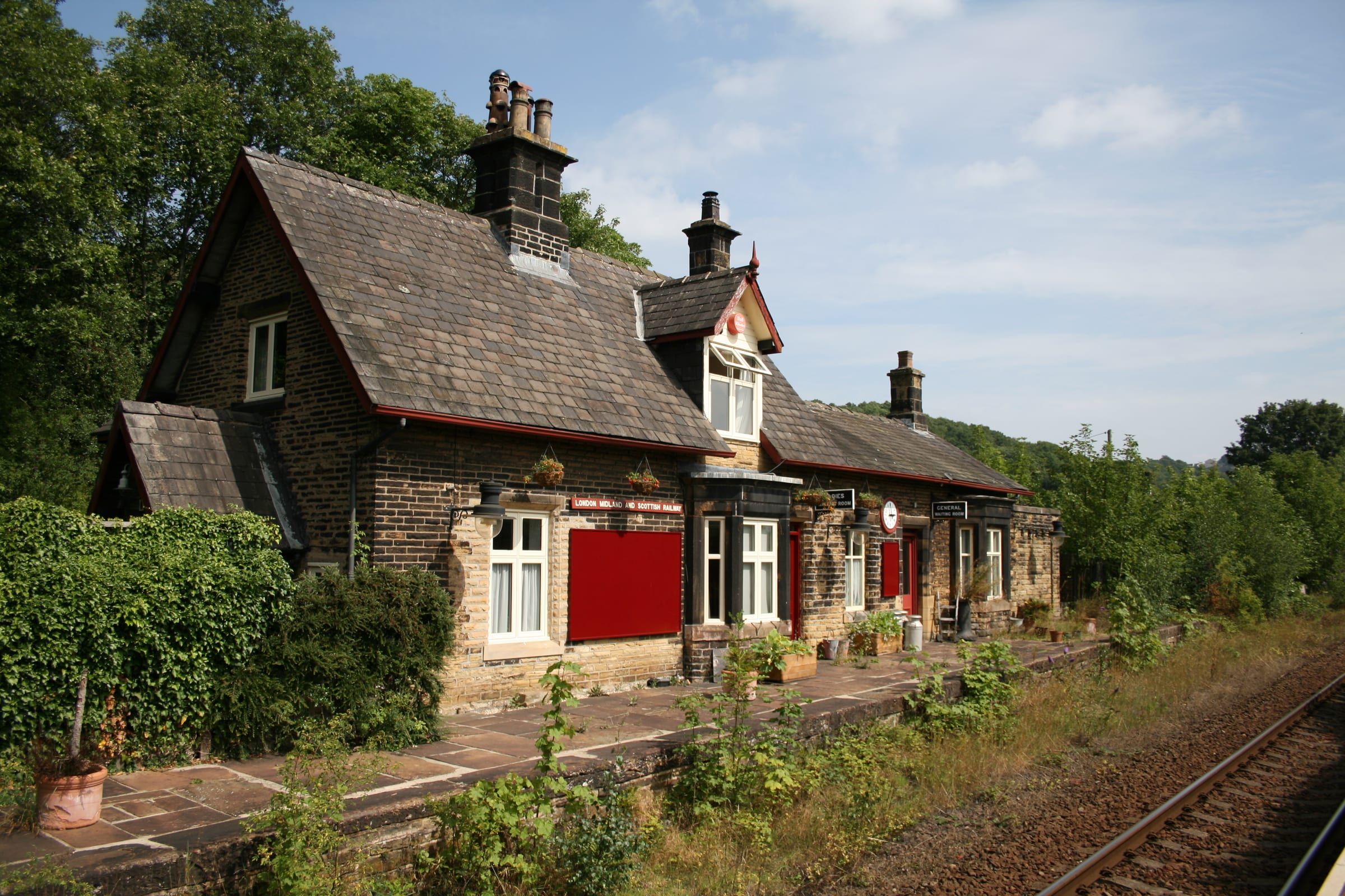 Former railway station building with new timber windows and red front door