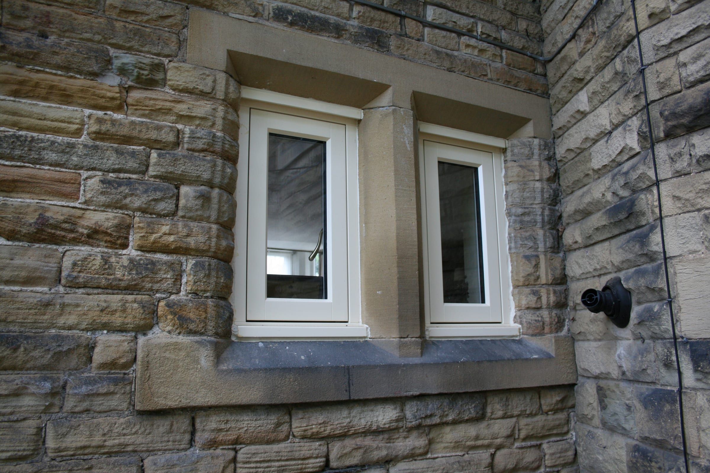 Close-up of new Accoya timber casement windows set in stone surrounds