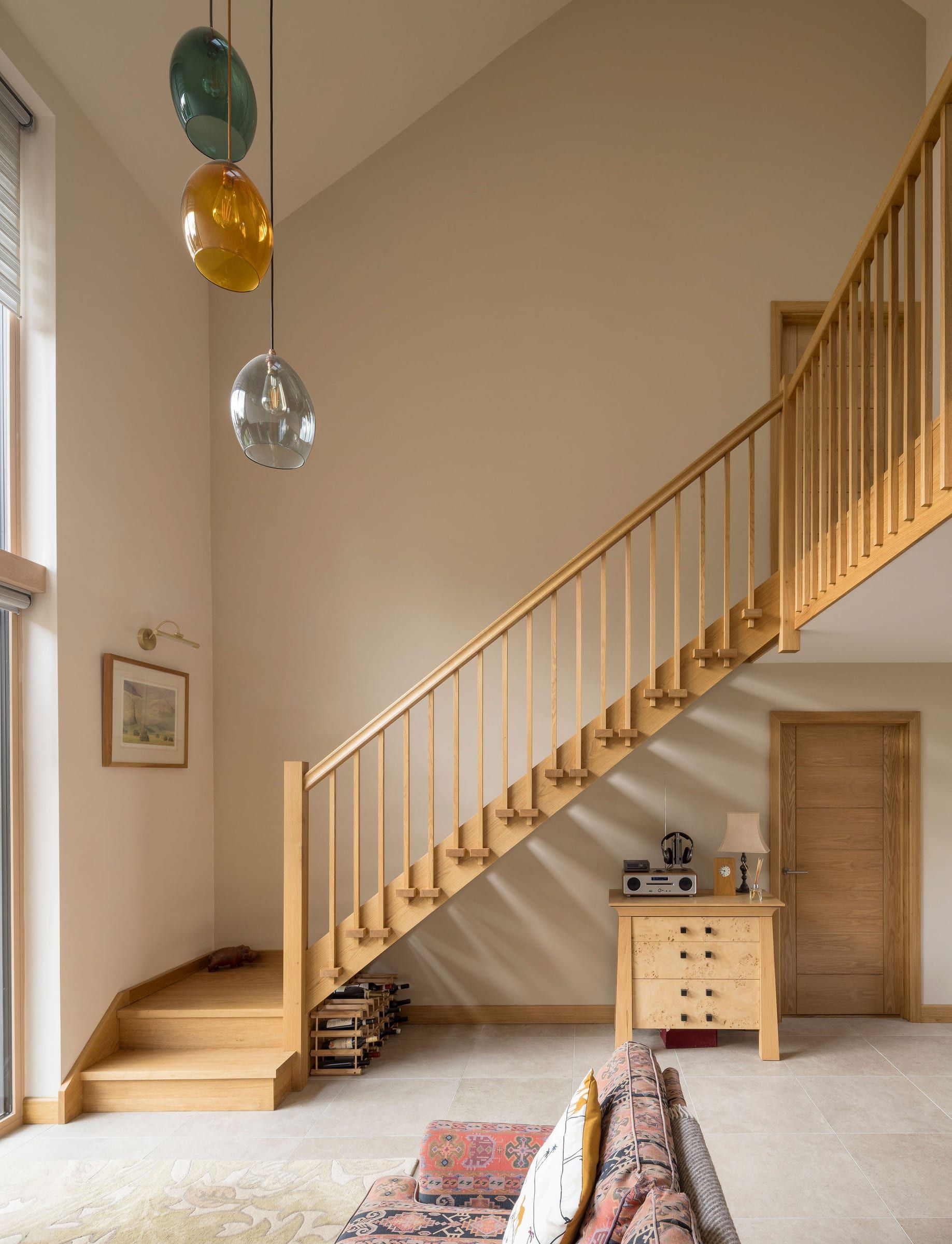 Oak open-tread staircase with slatted balustrade in double-height hallway