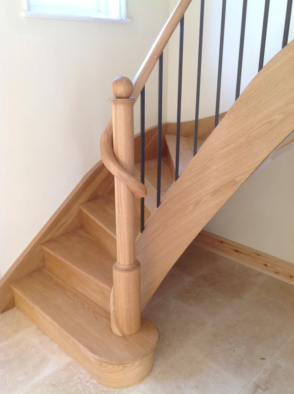 Oak winder staircase with turned newel post and metal spindles