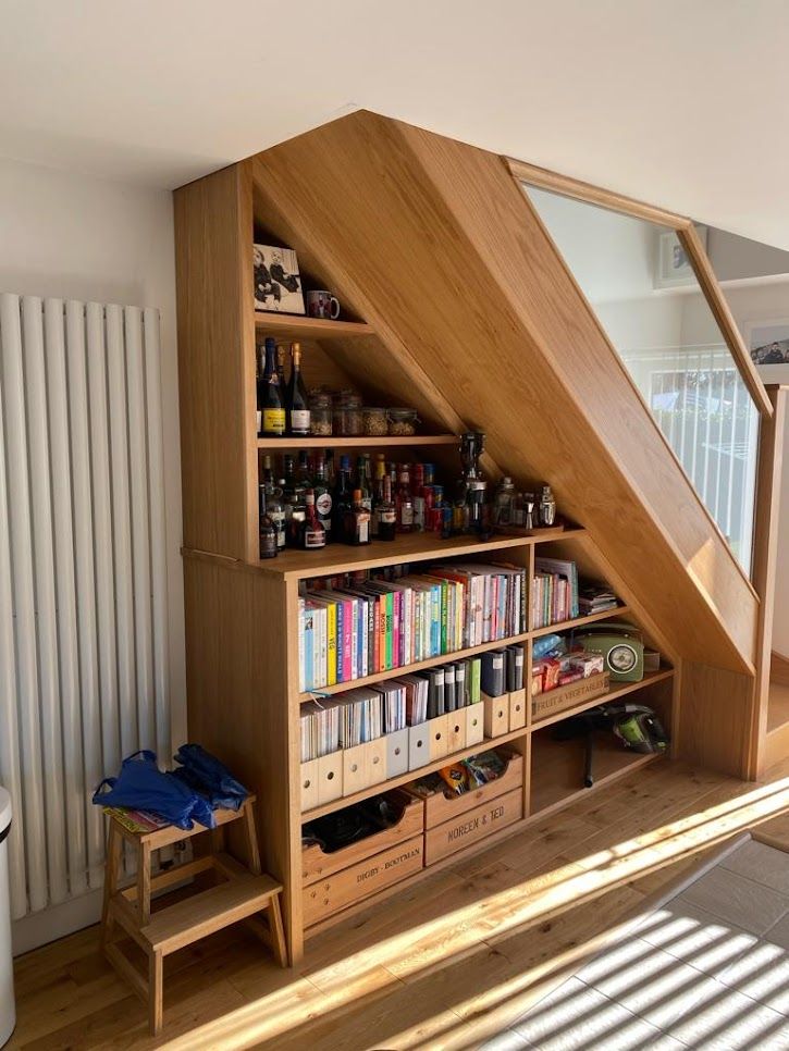 Understairs shelving filled with books, drinks bottles and labelled storage boxes