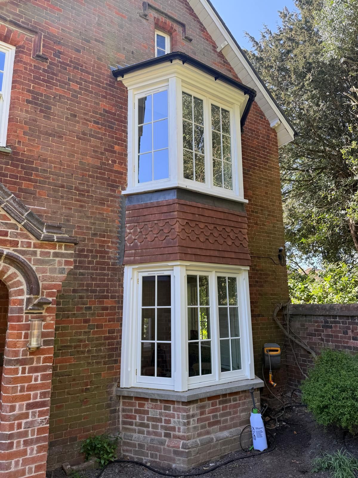 Two-storey stacked bay windows with vacuum glass on red-brick house corner